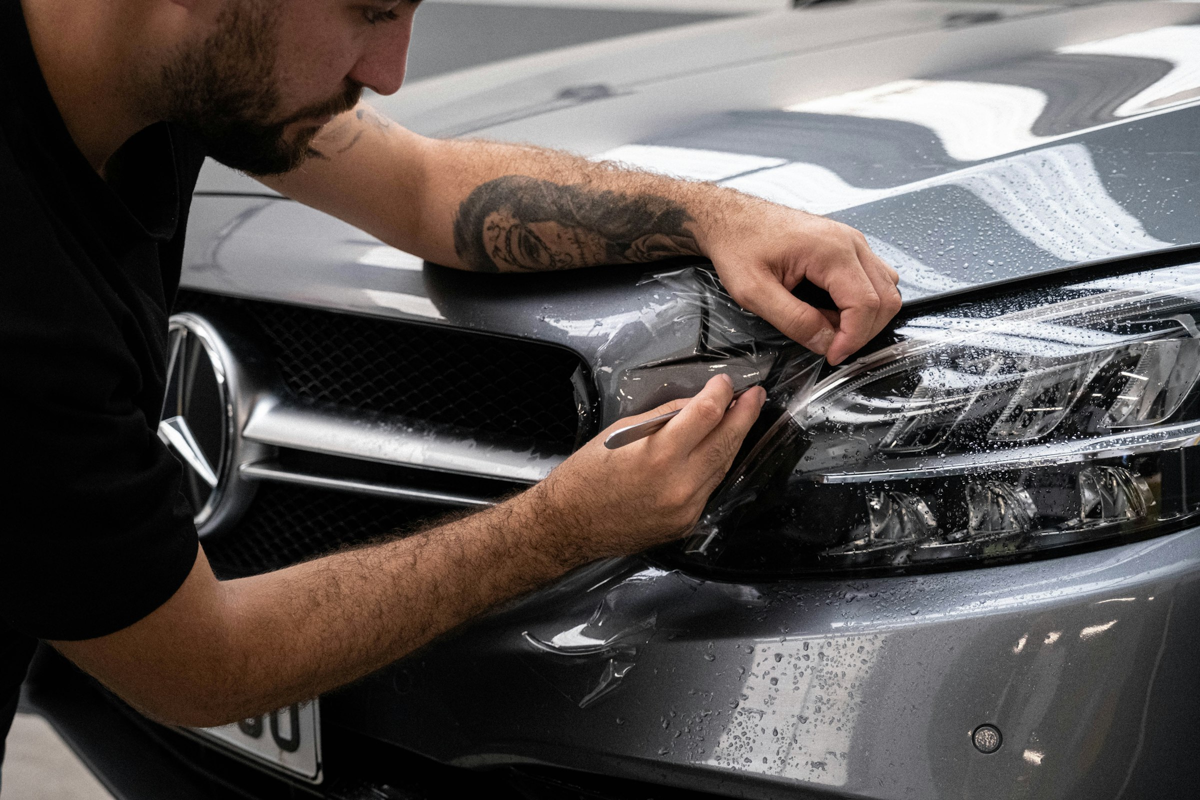 Mercedes farına PPF film uygulayan teknisyen